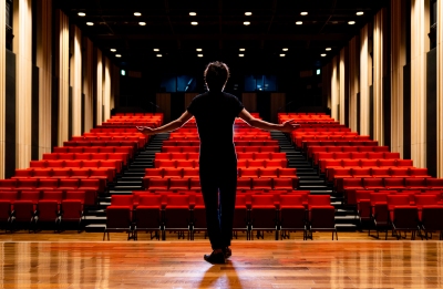 Image of actor on stage - empty theatre